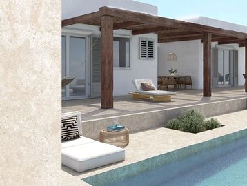 Beige limestone swatch of porcelain tile around a blue mosaic swimming pool in the house backyard