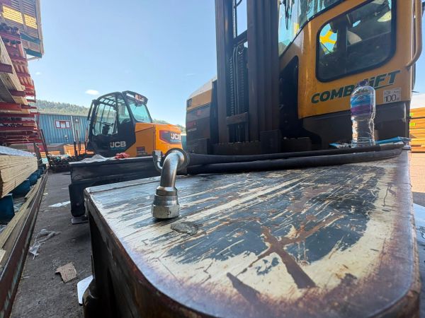 Construction equipment and a hydraulic hose on a wooden surface.