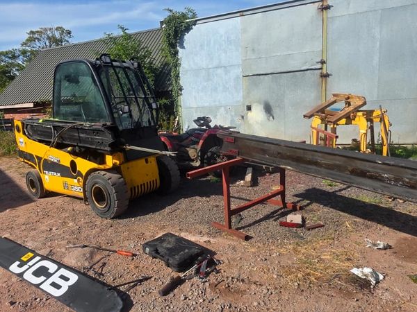 Yellow forklift lifting a large metal beam outdoors.