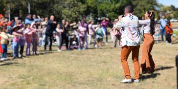Group dancing performance outdoors with audience.