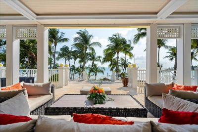 Tropical patio with palm trees and ocean view.