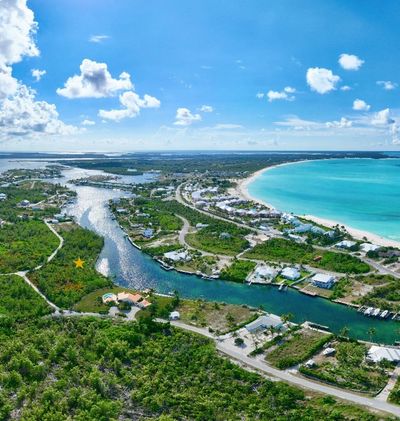 Aerial view of a coastal town with turquoise waters and green land.