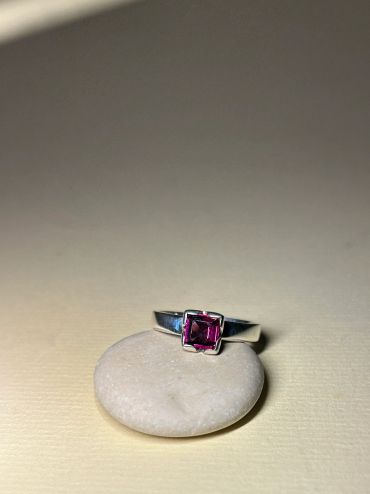 Anillo con piedra rosa sobre piedra blanca.
