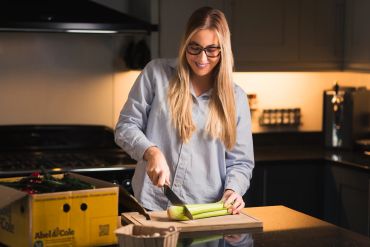 Woman cutting celery in kitchen.