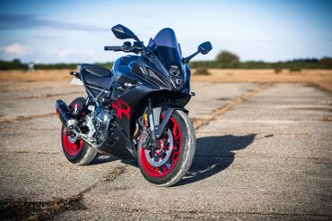 Black sport motorcycle with red accents on an empty road.