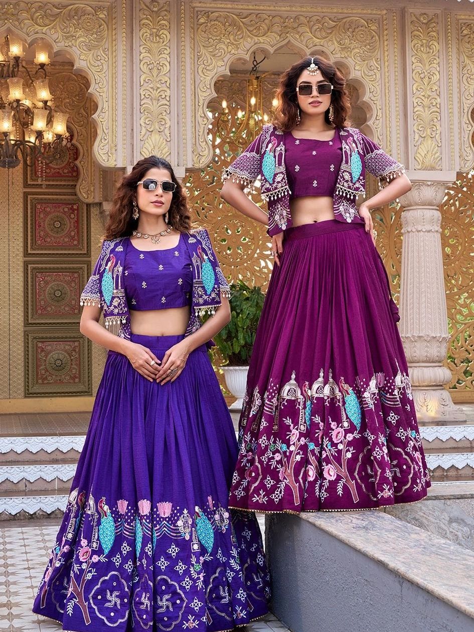 Two women in purple traditional dresses with elaborate patterns.