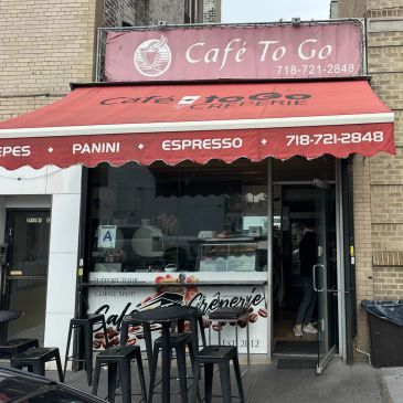 Exterior view of Café To Go with outdoor seating and red awning.