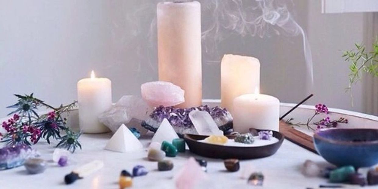 Candles, crystals, and incense create a calm, spiritual atmosphere on a table.