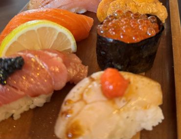 Close-up of assorted sushi pieces on a wooden platter.