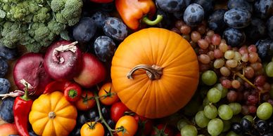 Assortment of fresh fruits and vegetables including pumpkins and grapes.
