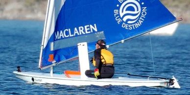 White mainsheet hanger clips on a Sunfish boom are clearly seen in this image. 