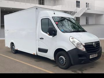 White delivery van parked on a street near a building.