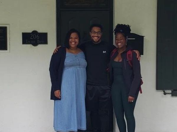 Three clinicians outside in front of a building. 