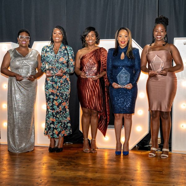 Women standing together receiving an award. 