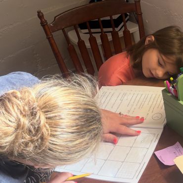 A child receives help with math homework.