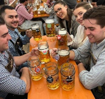Group of friends enjoying large beers at a festive gathering.