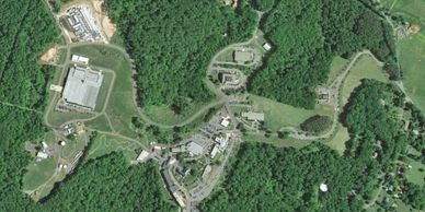Aerial view of a buildings complex surrounded by dense forest.