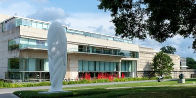 Modern building with outdoor sculpture and greenery.