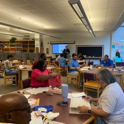 Adults studying and collaborating in a classroom setting.