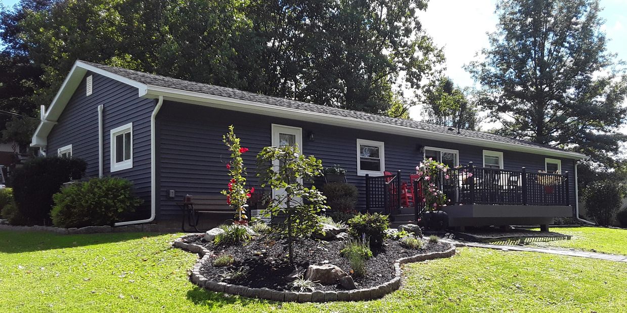 New Azek pvc deck with aluminum railing, new stone patio, new siding, and new landscaping installed 