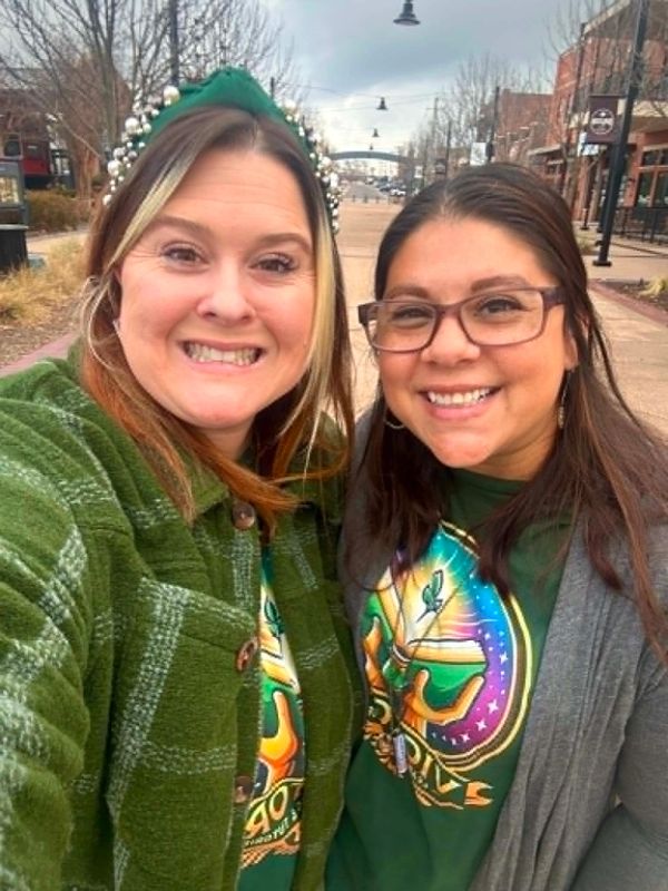Two smiling women posing for a selfie outdoors.