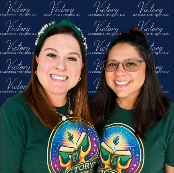 Two smiling women wearing green Victory Learning &amp; Tutoring LLC shirts.