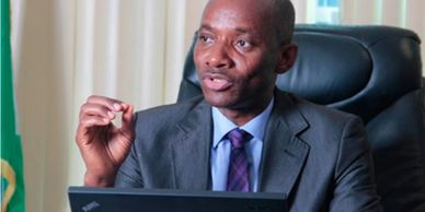 A man in a suit speaking during a meeting.