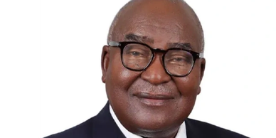 Portrait of an elderly man wearing glasses and a suit.