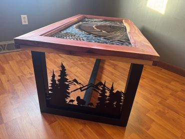 Handcrafted wooden table with bird feather mosaic and metal nature silhouette.
