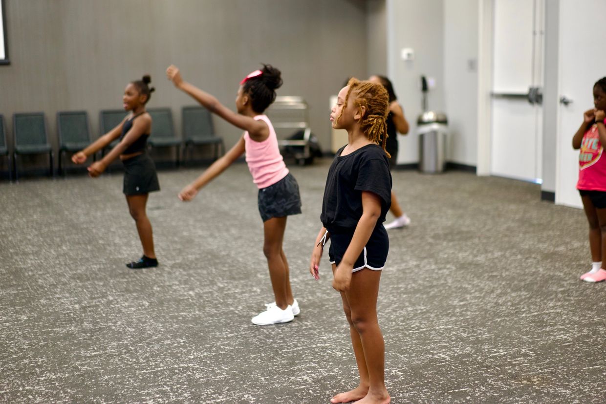 Children practicing dance moves in a studio with focus and energy.