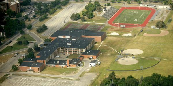 Aerial view of a school with sports fields and parking lot.