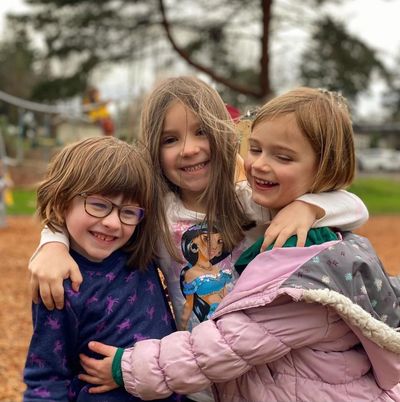 Three kids meet with smiling faces.

