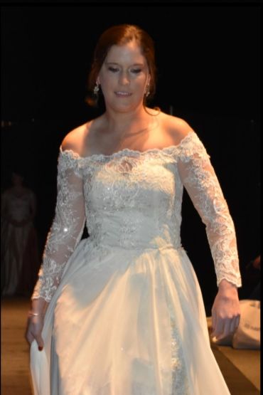 Woman in an elegant white lace wedding dress at an event.
