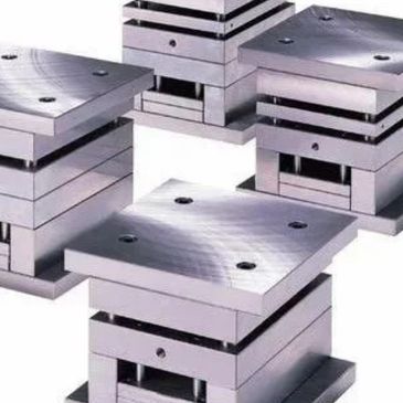 Shiny metal industrial molds used for manufacturing.