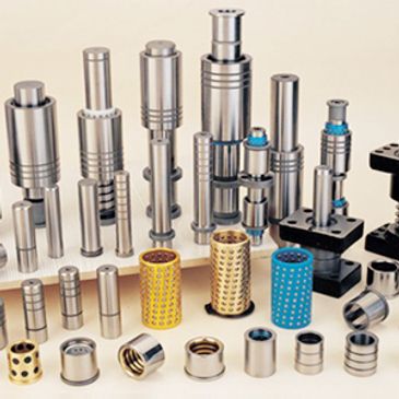 Various metal industrial components and bushings arranged on a surface.