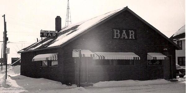 Old black and white photo of a bar in winter.
