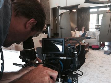 Shane George operating RED EPIC-X cinema camera on a film set during an indoor video production 