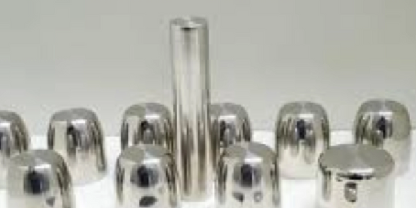 Various polished metal objects of different shapes and sizes on a white surface.