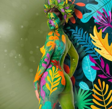 Woman covered in vibrant jungle-themed body paint matching the background.