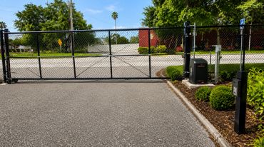 Closed metal gate blocking entrance on driveway.