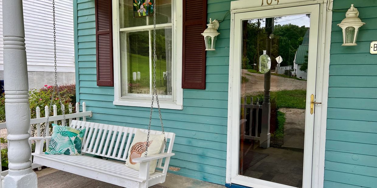 The River House – A beach-inspired retreat with a front porch swing and river view.