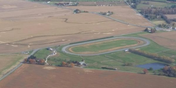 Aerial view of a rural horse racing track surrounded by farmland.