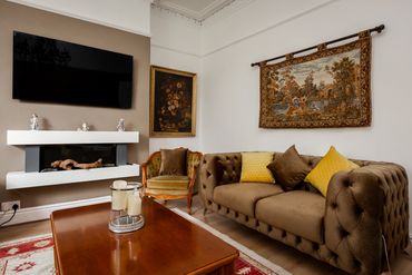 Living room with period features, three comfortable sofas, electric fireplace, smart TV to relax.