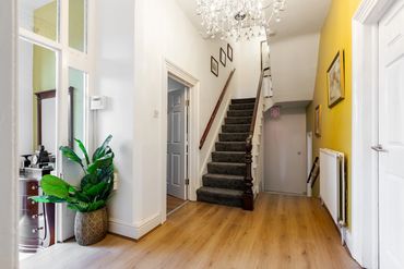 Very spacious common areas with a period staircase featuring chandeliers and its original balustrade