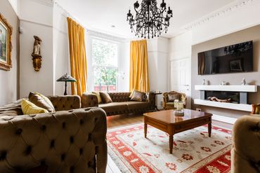 Living room with period features, three comfortable sofas, electric fireplace, smart TV to relax.