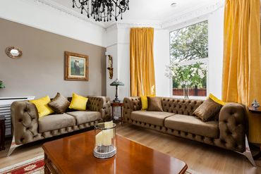Living room with period features, three comfortable sofas, electric fireplace, smart TV to relax.