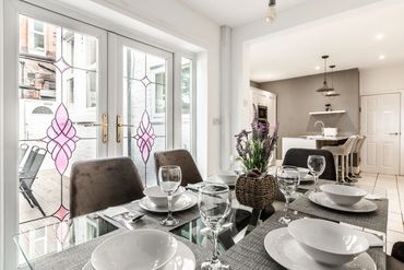 Modern kitchen with double oven, wine cooler, six-ring gas hob, freezer, three fridges, and dishwash