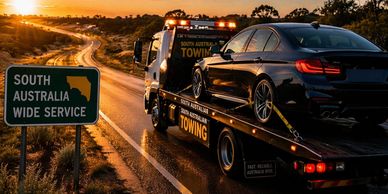 Tow truck transporting a vehicle across long-distance highway in South Australia