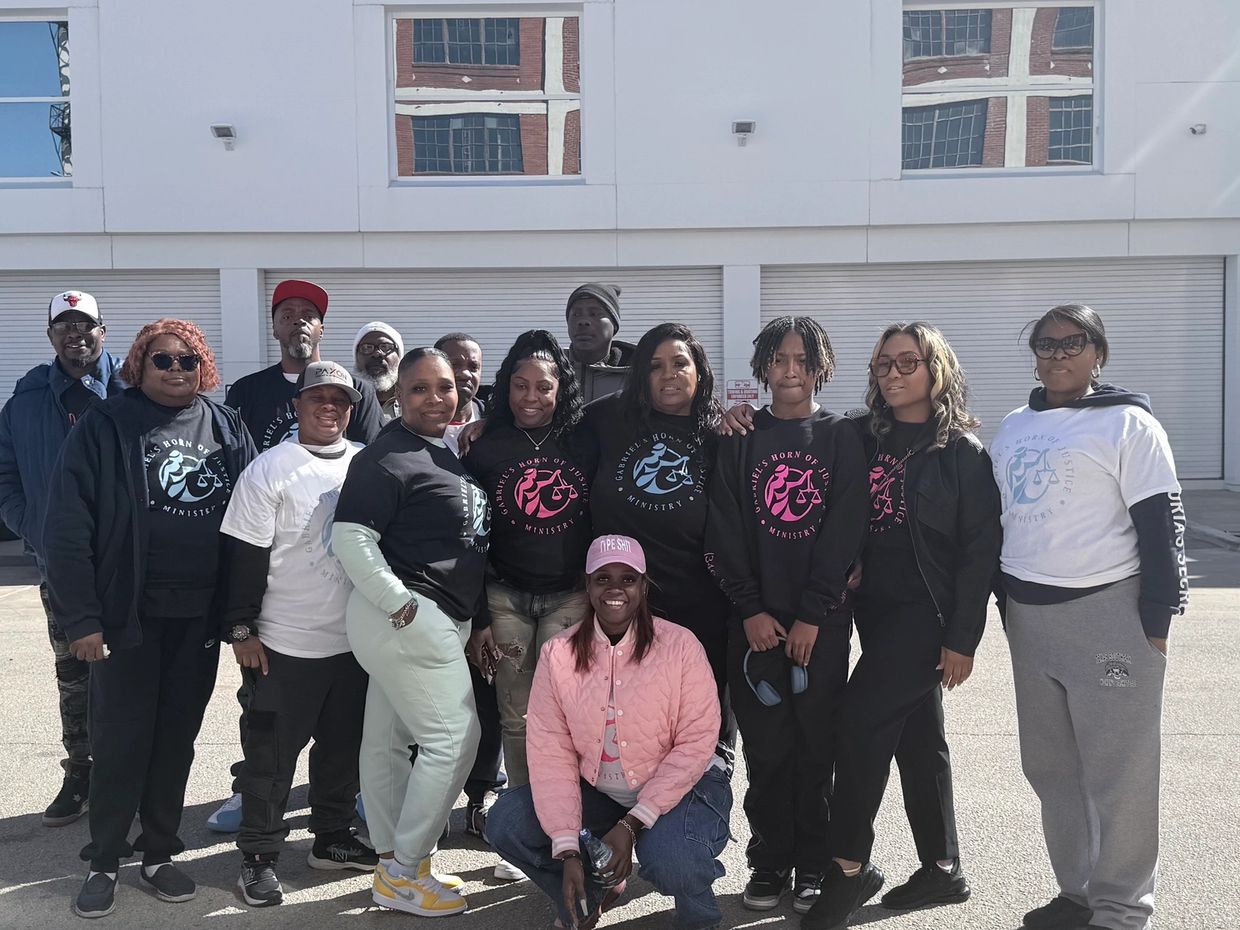 Group of people posing outdoors with matching ministry shirts.