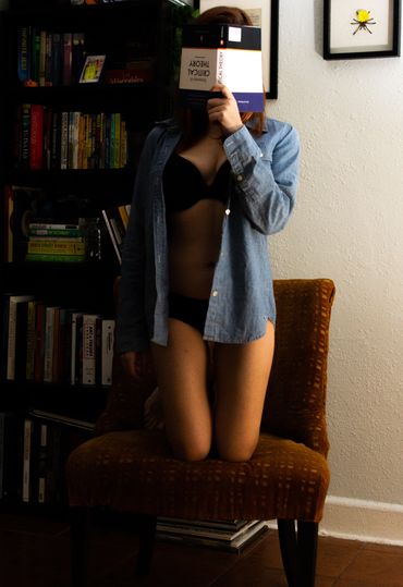 woman in bra and underwear reading a book